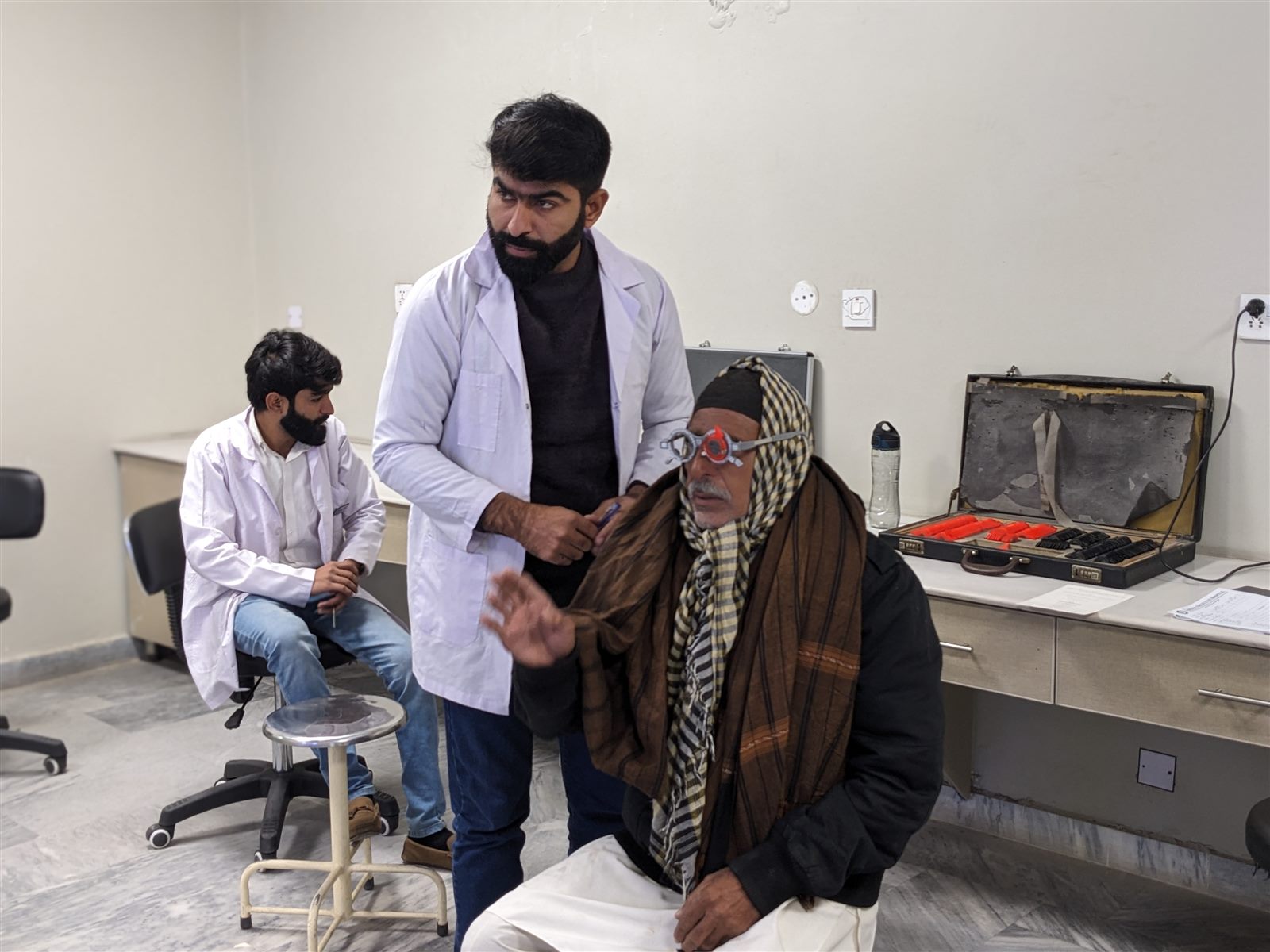 Eye specialists conducting a vision examination for a patient at Sardar Trust Eye Hospital